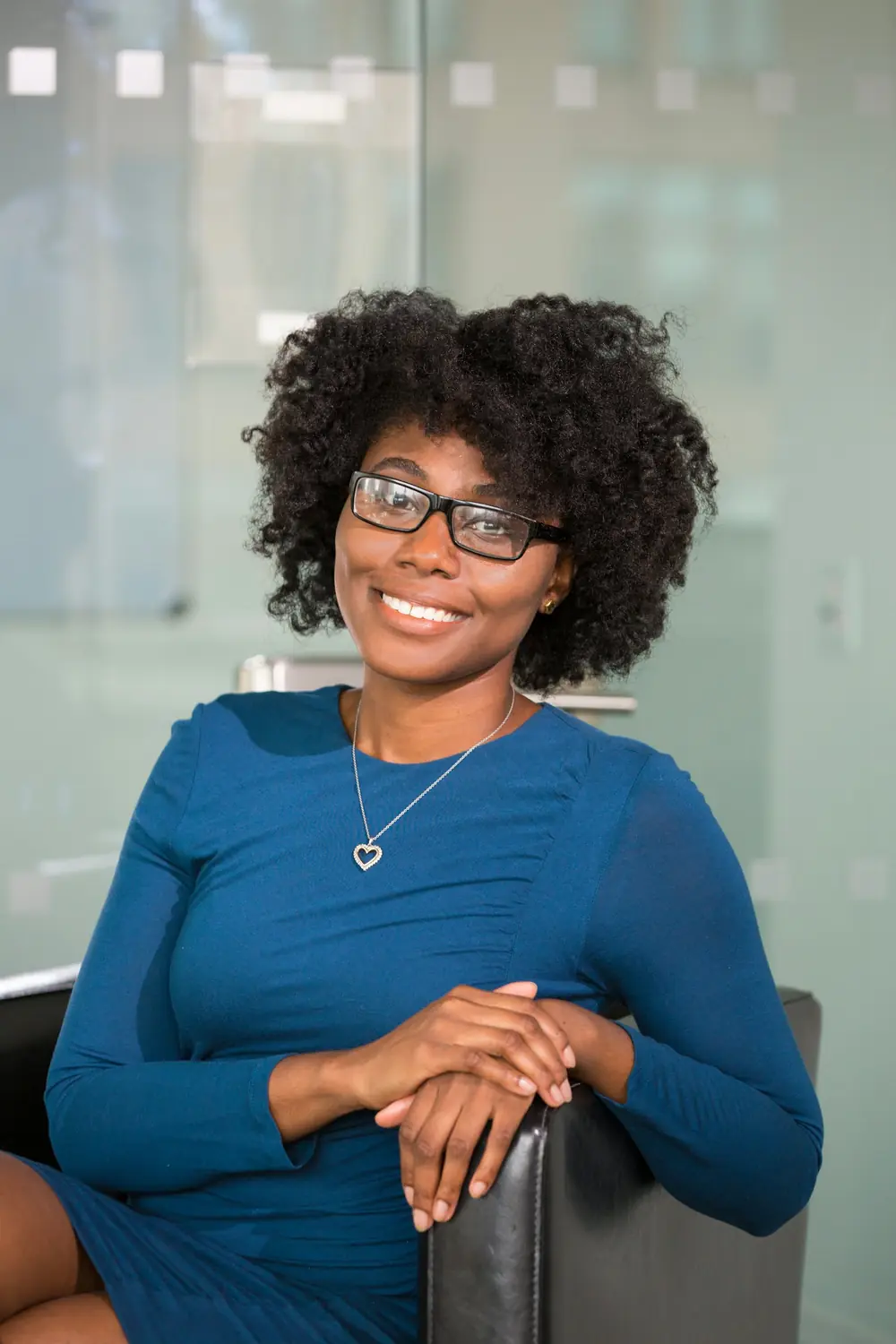 A professional woman holding a laptop, smiling
